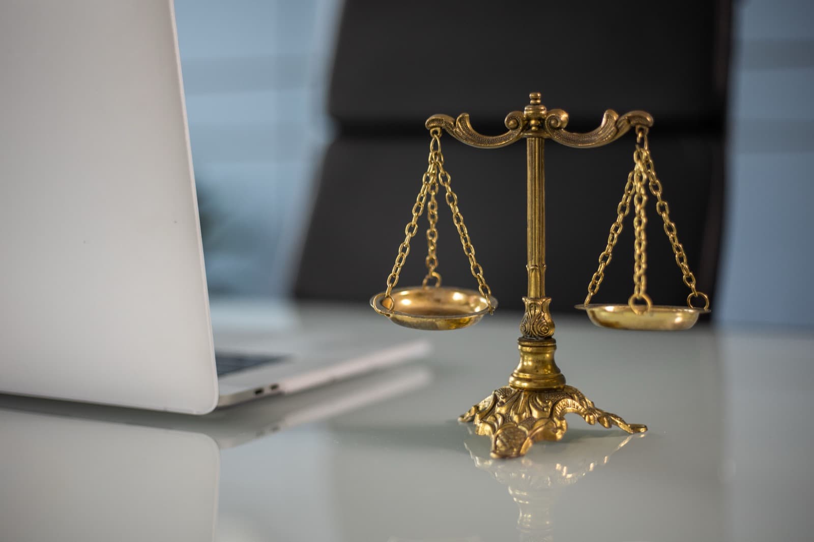Balanza de la justicia dorada sobre un escritorio claro de oficina